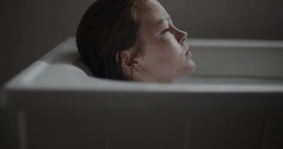 A woman lying in cloudy bath water
