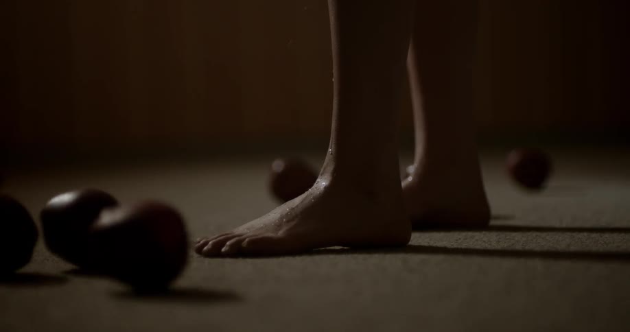 Apples roll towards a persons feet