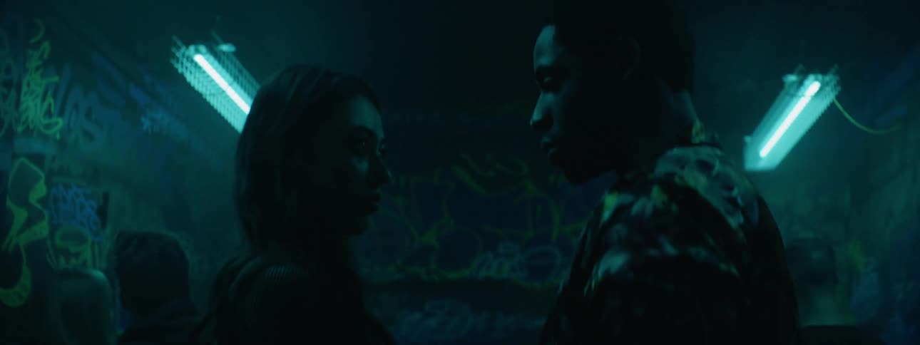 Woman and man holding hands and staring at each other in the middle of the night club