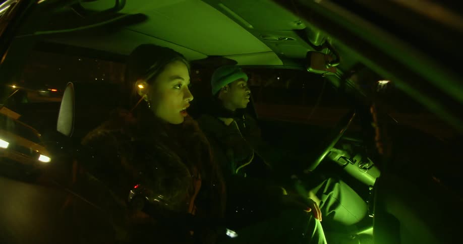 A woman and man are in a vehicle arguing with each other while driving down the road