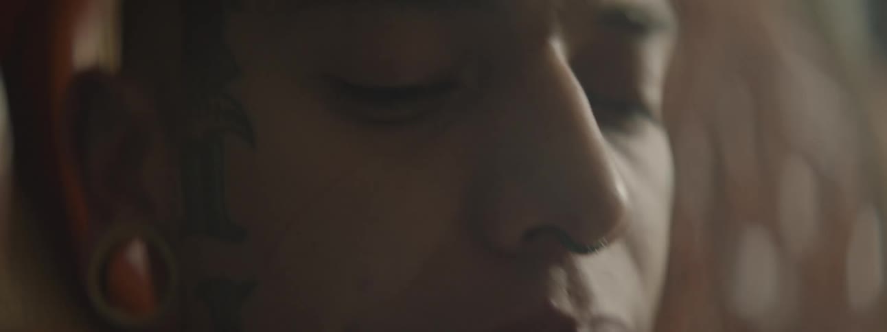 Close up view of a young male blowing smoke out of his mouth