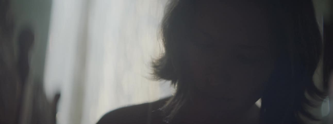 This silhouette of a woman is visible in a dimly lit room