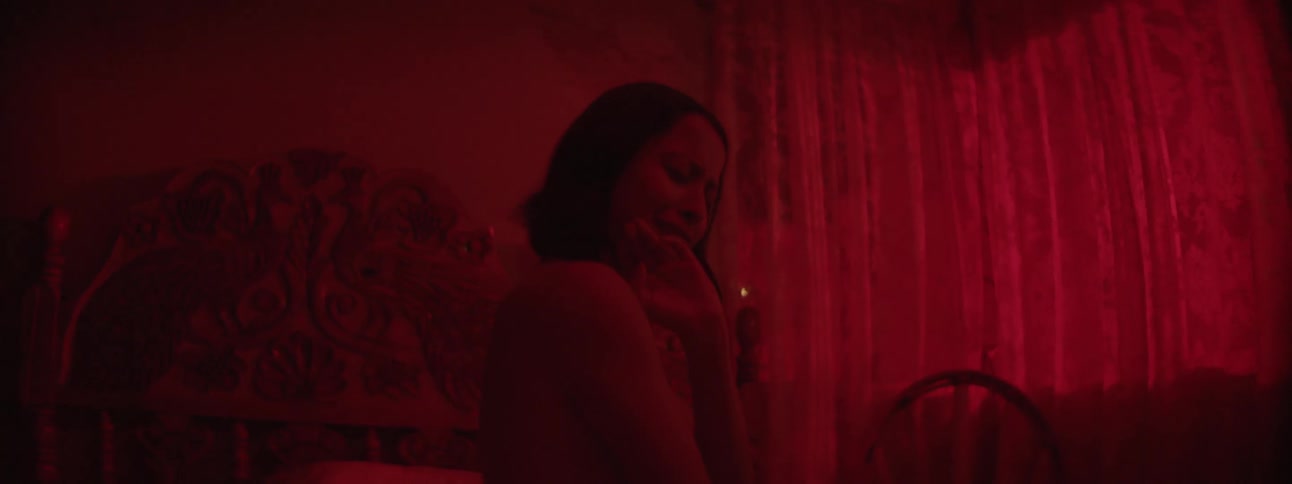 A woman sits in the dark