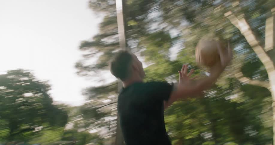 A man shoots baskets outside
