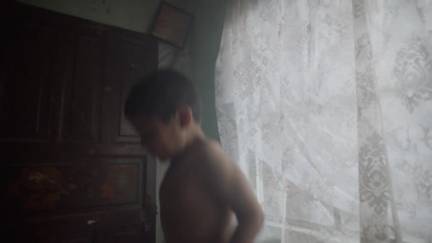 Boy jumps on bed while another boy lies down