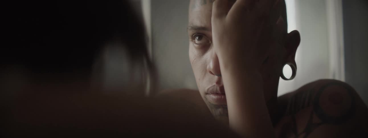 Tattooed man receiving a blessing on forehead from woman