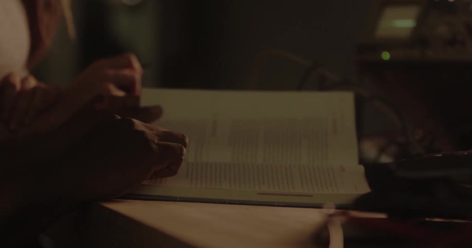 A girl and a boy read a book in the dark