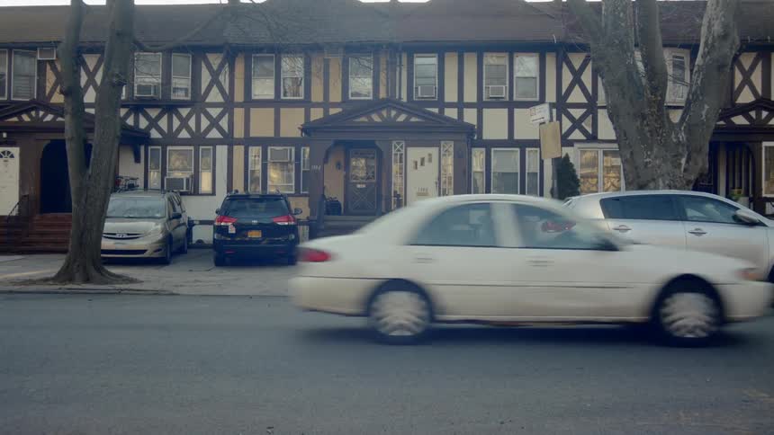Vehicles parked outside of a row of houses