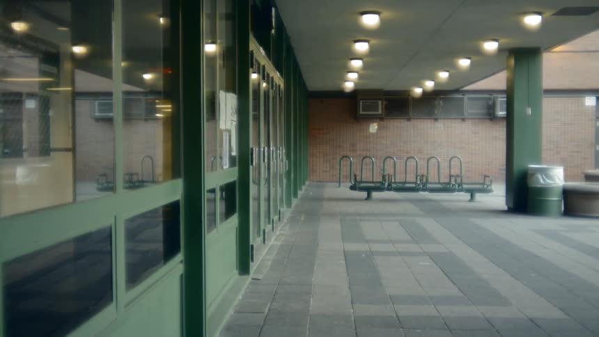 Lights shine under an awning of a high school building