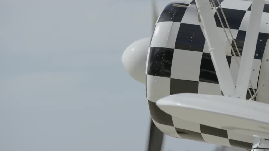 Propeller turning on a checkerboard  covered  prop plane