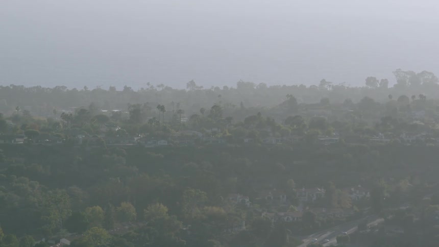 Aerial view of a city with many trees on a hazy day