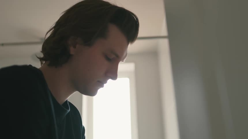 A man looks down in the room
