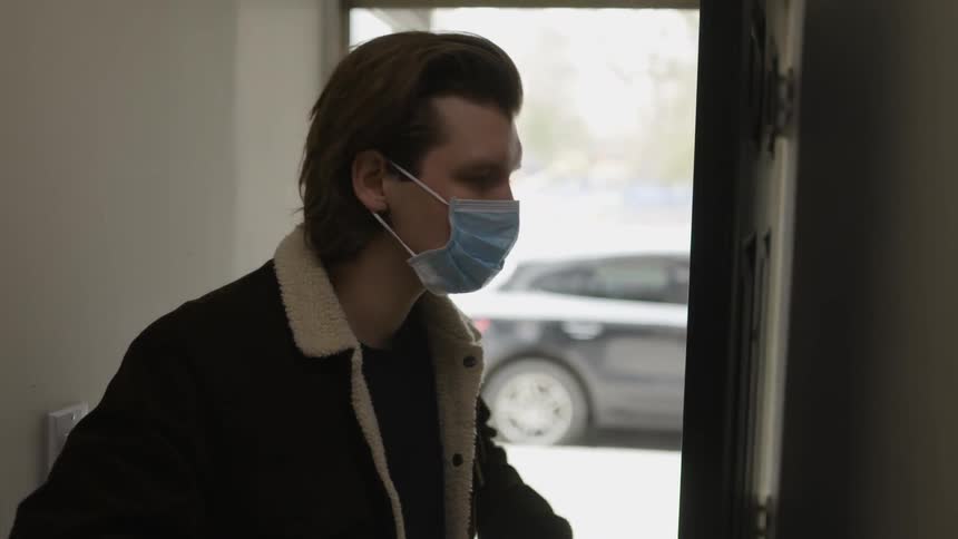 A man is plugging on a surgical mask