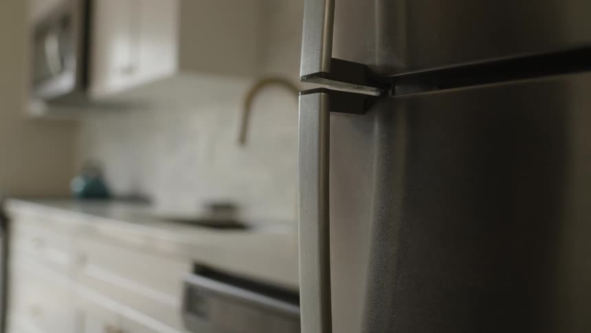 A person wipes the handle on their fridge door