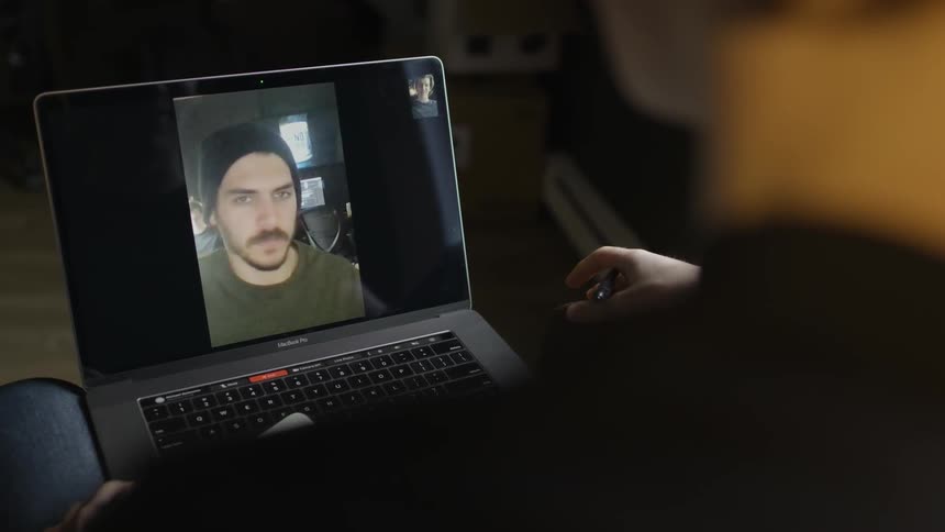 A person using a laptop to video chat with a man