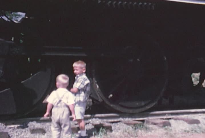 Kids standing in front of train wheels