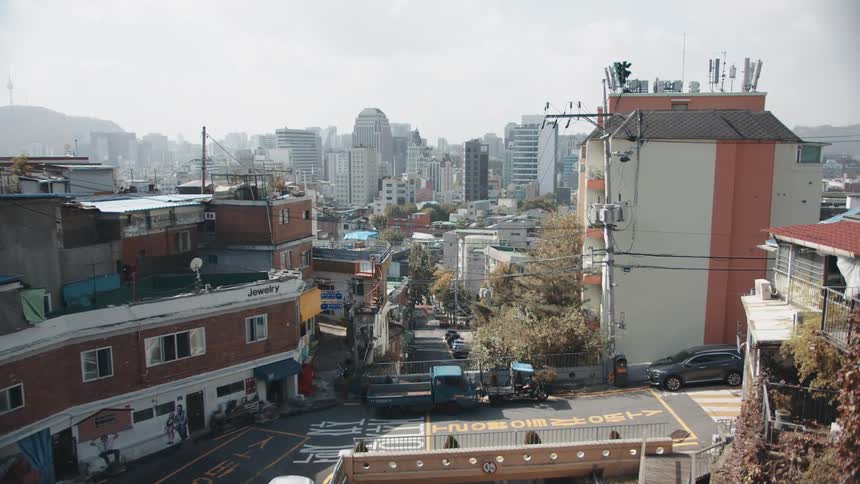 A pickup truck passes through a dense but empty city neighborhood