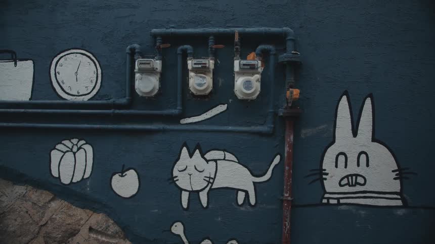 Cat and rabbit drawn on blue building wall near meters