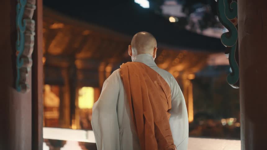 A monk walking along a balcony in a temple