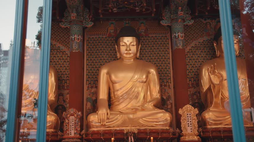 Large buddah statues sit inside a building