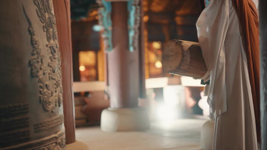 Monks use log on swing to ring ornate bell