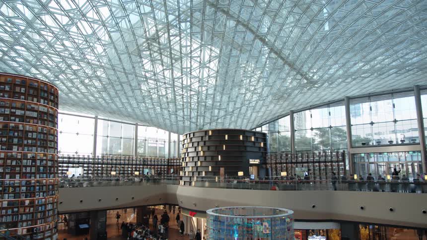 A glass topped building with distinctive architecture full of people and books