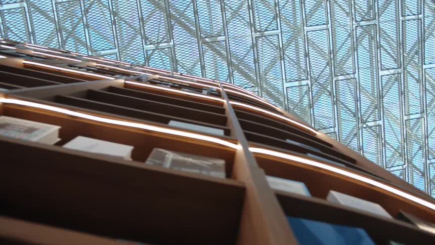 A modern style of architectural building with bookshelves from floor to glass ceiling