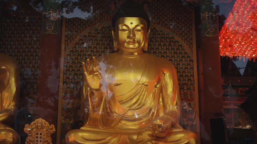 A golden buddha statue sits inside a building