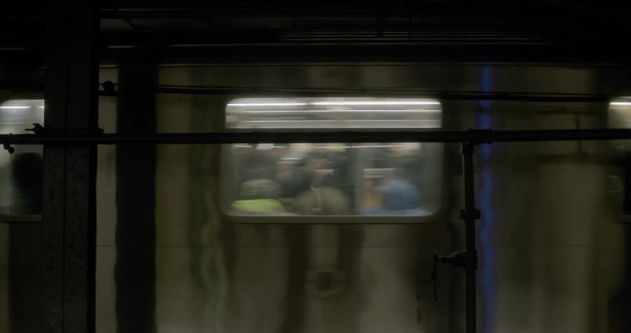 Subway car leaving platform full of people