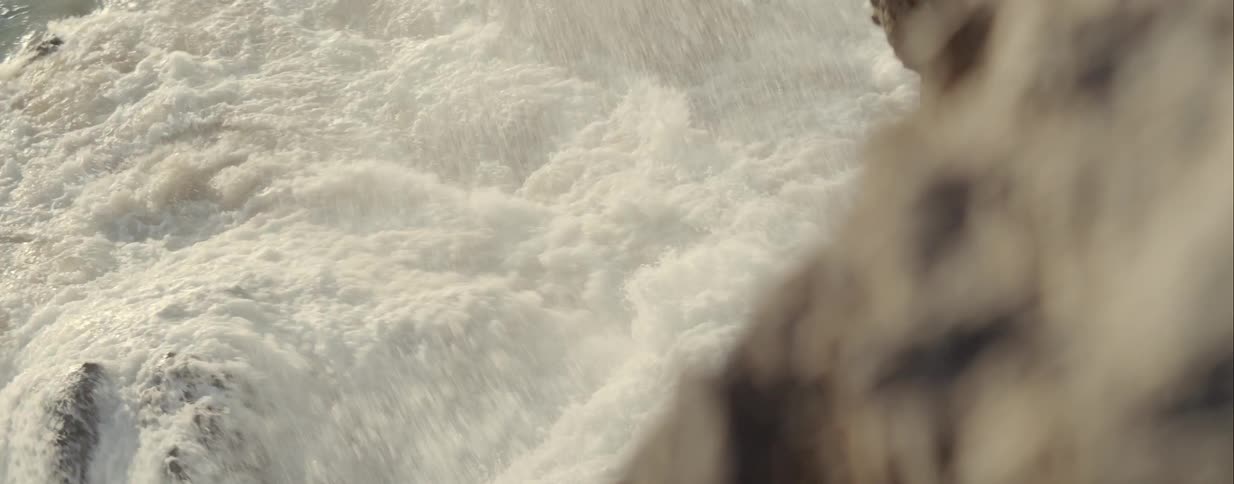 Foamy ocean water crashes over the rocks