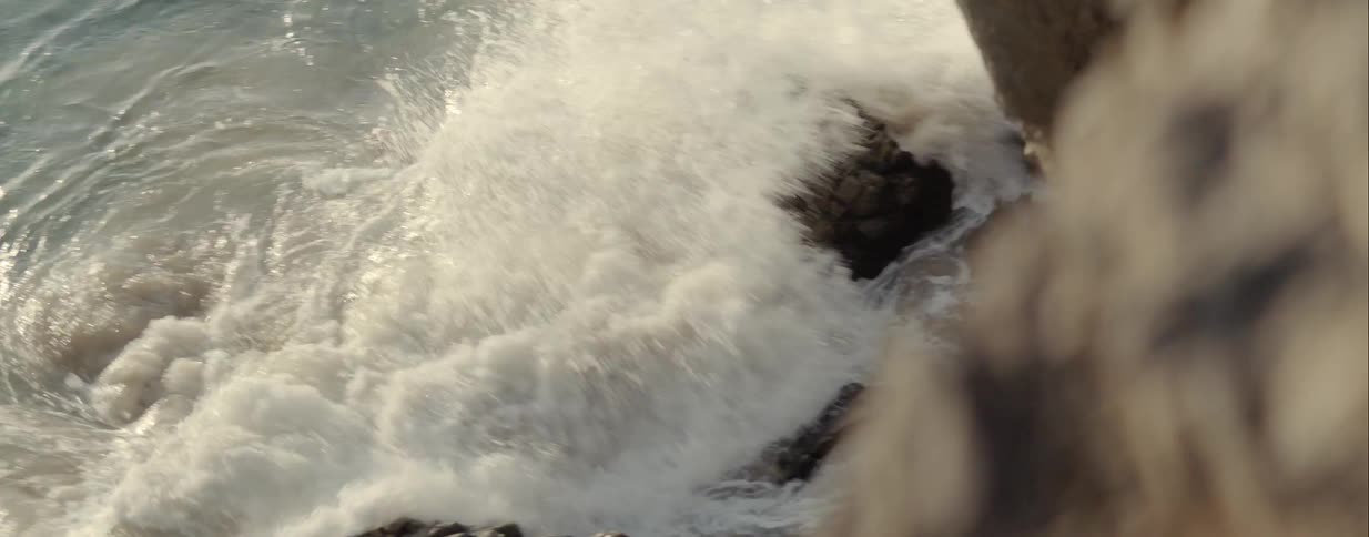The waves crash against the rocks