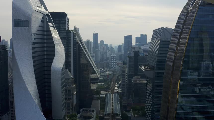 A small bridge connects vehicles driving in a large city