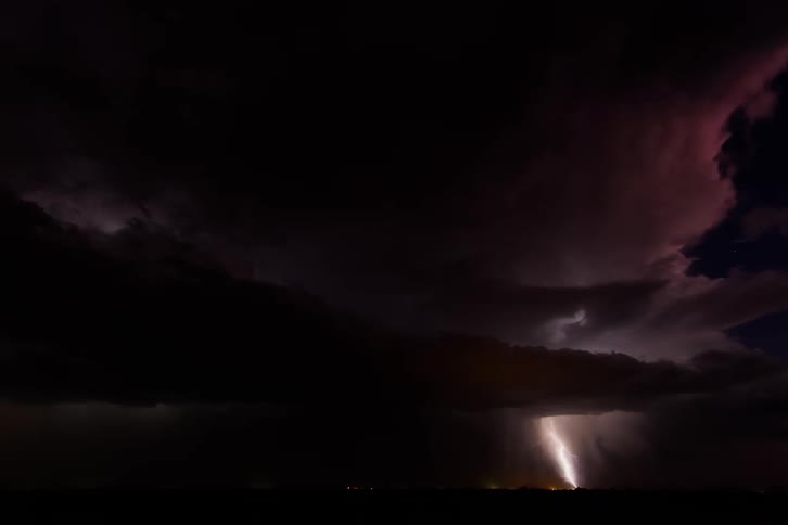 Lightning flashes and clouds roll across the sky