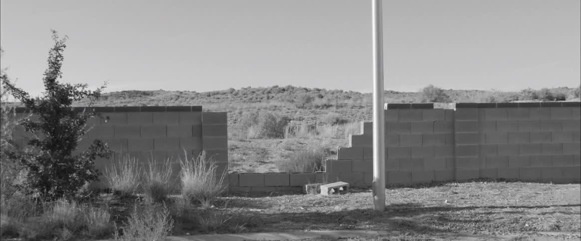 A broken wall in front of a hill