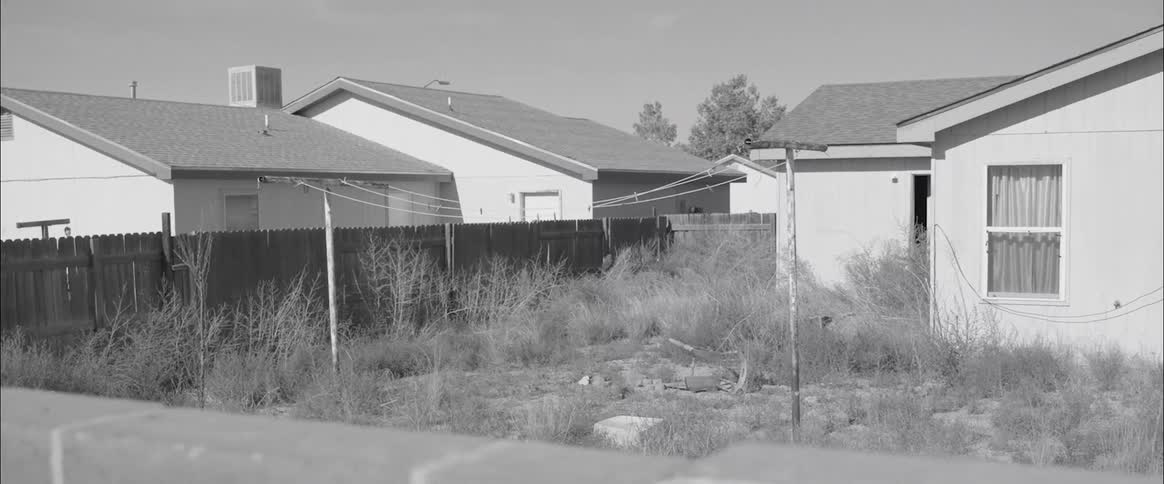 Black and white footage of low income housing backyards