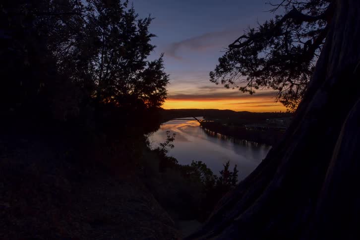 The sun rises over a river