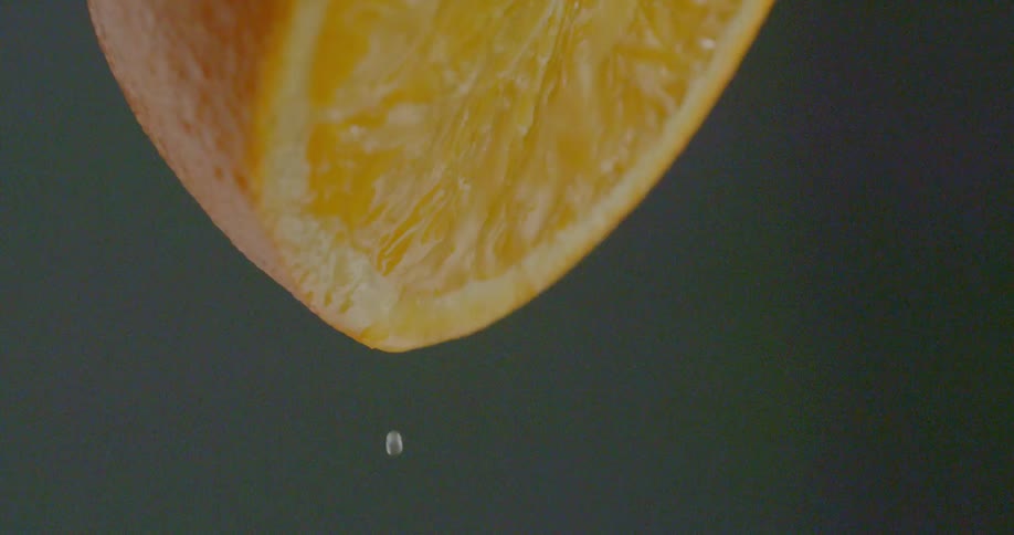 Drops of juice fall from orange half