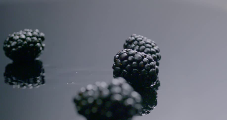 Blueberries falling on to a wet surface