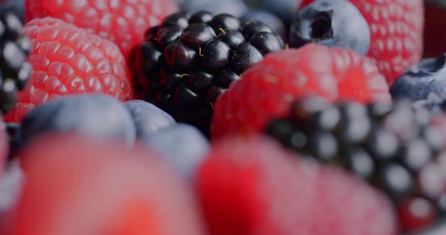 The plate is full of blueberries and raspberries