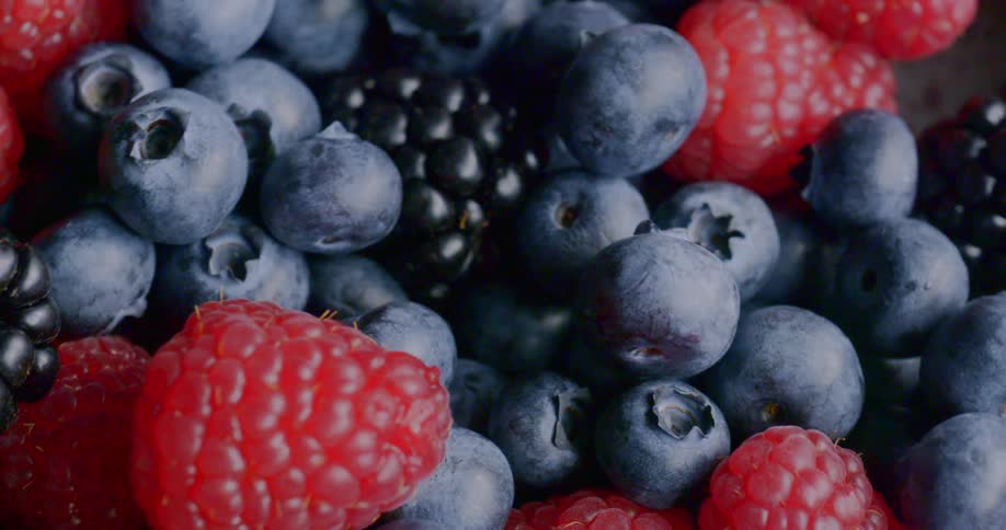 Raspberries blackberries and blueberries piled together