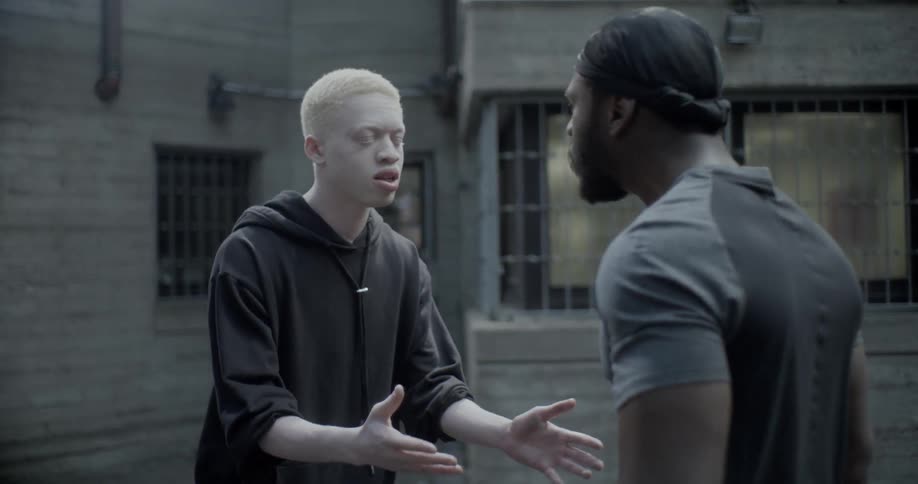 Two people argue with each other and one man pushes a smaller teenager