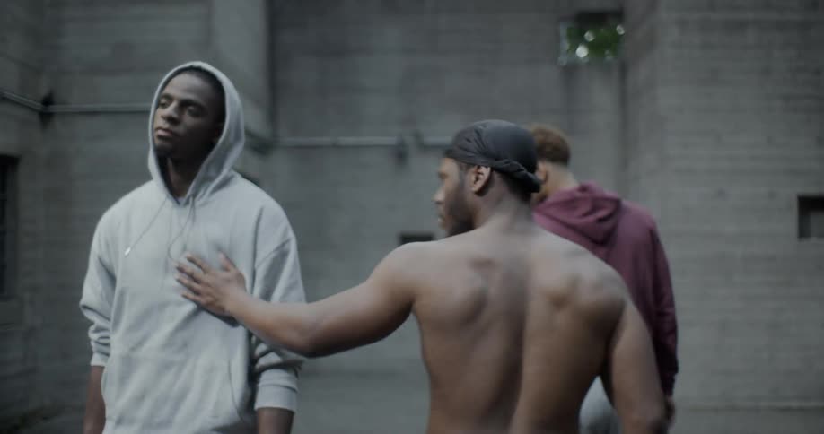 Three young black men walk away from something