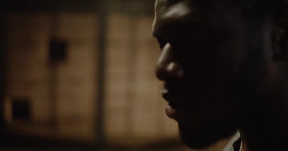 Black man backlit in empty room