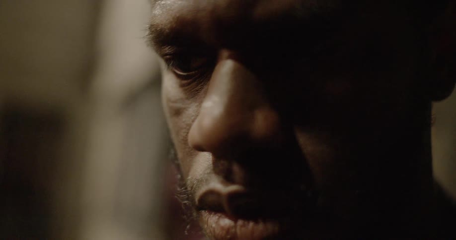 A man is looking down in a dark room