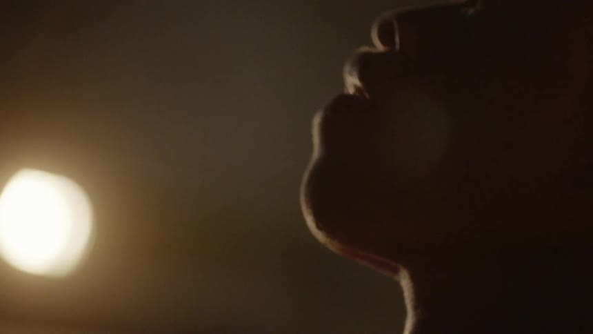 A man looking upwards with a basketball in his hand