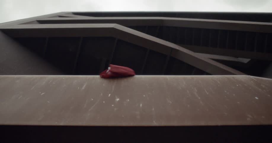 A person leans over the railing of the staircase