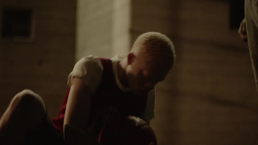 Man holding a basketball rises from the floor and tosses the ball