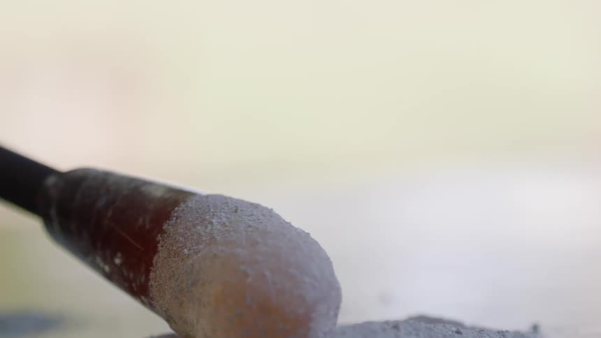 A person rolls the glass in the sand