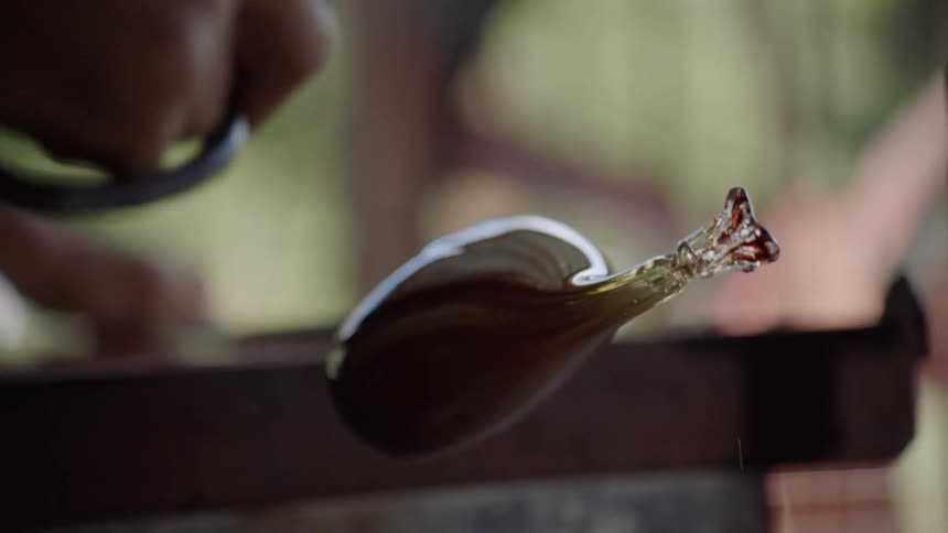 Glass maker shapes glass with a tool