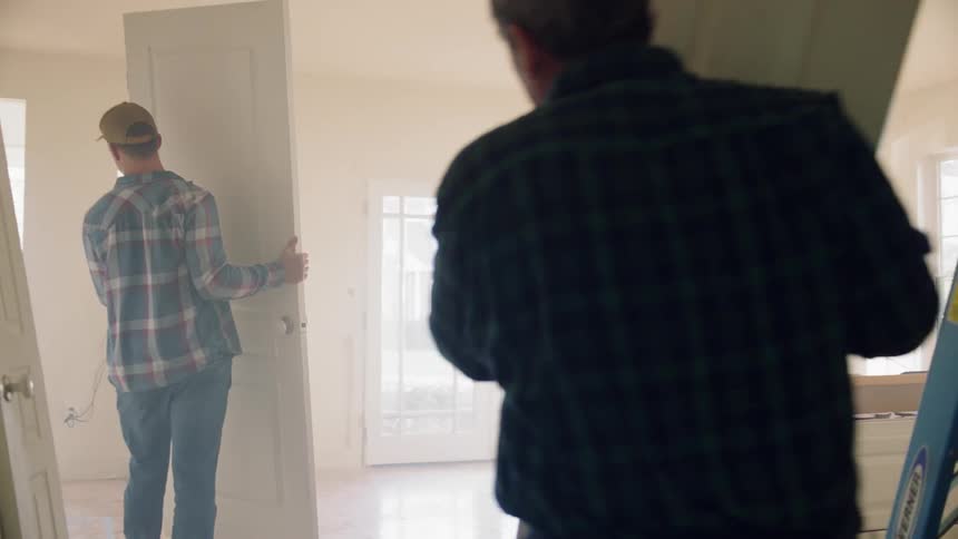 Men carrying doors in to a room
